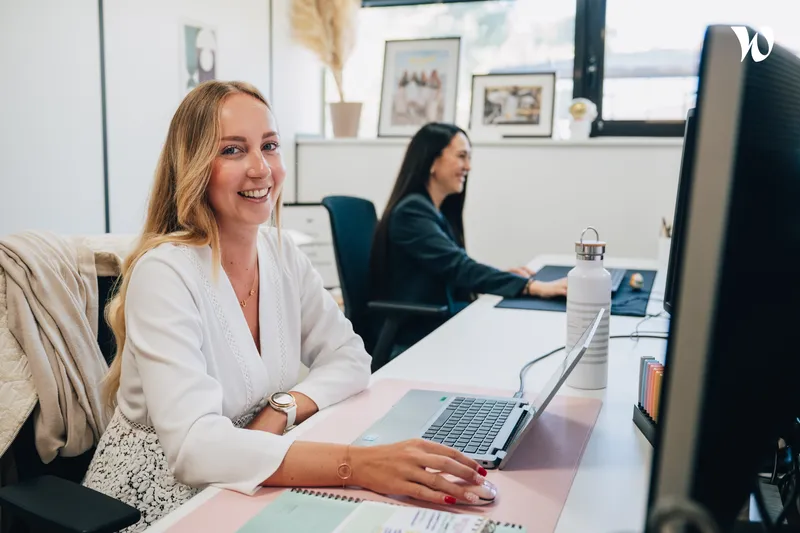 jeune femme souriante assise à son bureau