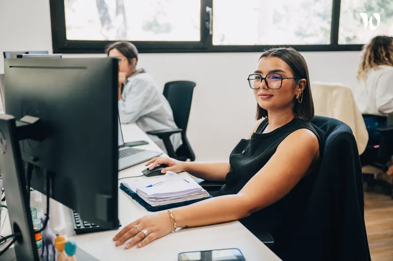jeune femme assise à son bureau qui travaille