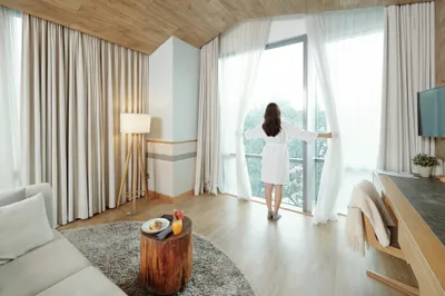 Woman opening curtains