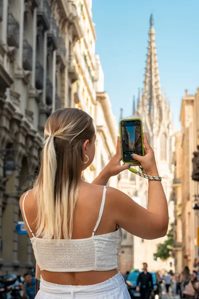 Blond young girl traveling in Europe. Ancient cathedral on Barcelona old town